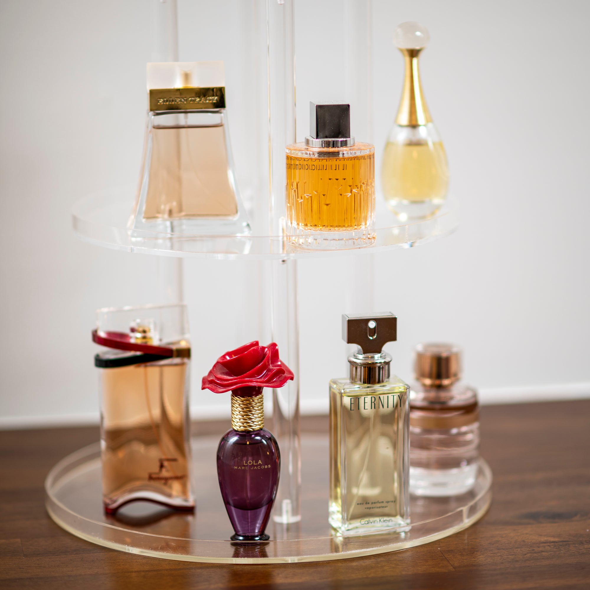 modern acrylic perfume stand with multiple tiers 